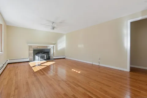 an empty room with wooden floor and fireplace