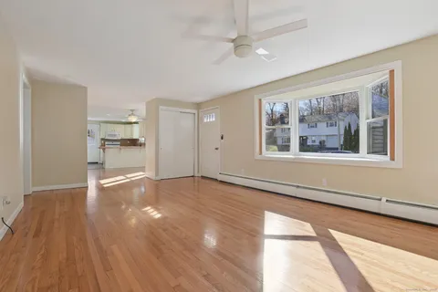 a view of empty room with wooden floor and windows