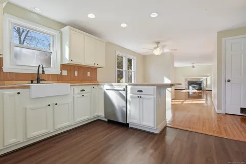 a kitchen with stainless steel appliances a sink dishwasher stove refrigerator and wooden floor