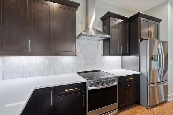 a kitchen with stainless steel appliances granite countertop a refrigerator and a stove