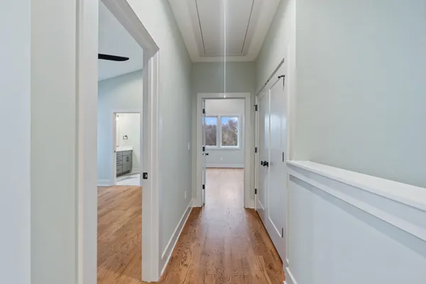 a view of a hallway with wooden floor and staircase