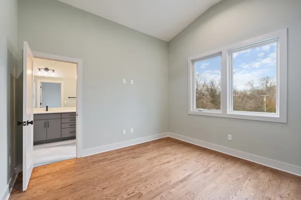 an empty room with a window and wooden floor