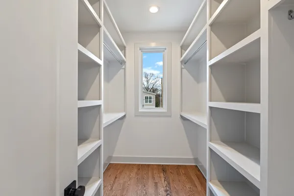 a view of walk in closet with wooden floor