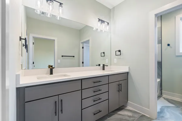 a bathroom with double sink and a mirror