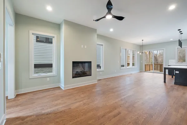 an empty room with windows and fireplace