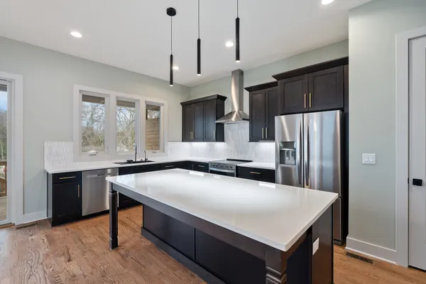 a kitchen with stainless steel appliances a table chairs refrigerator and microwave