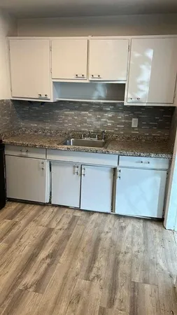 a kitchen with granite countertop a sink and a stove