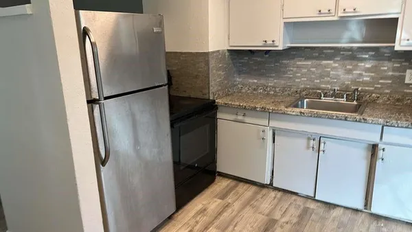 a kitchen with stainless steel appliances granite countertop a refrigerator and a sink