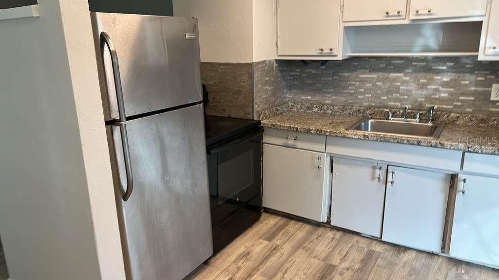 5000 Manduria Street Orlando, FL 32819 - Photo 5 of 17 a kitchen with stainless steel appliances granite countertop a refrigerator and a sink