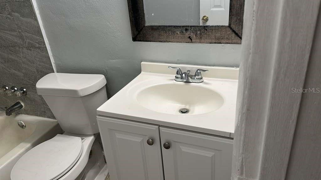 5000 Manduria Street Orlando, FL 32819 - Photo 10 of 17 a bathroom with a toilet sink and mirror