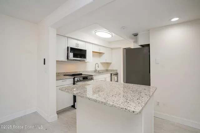 an empty room with wooden floor ceiling fan and windows