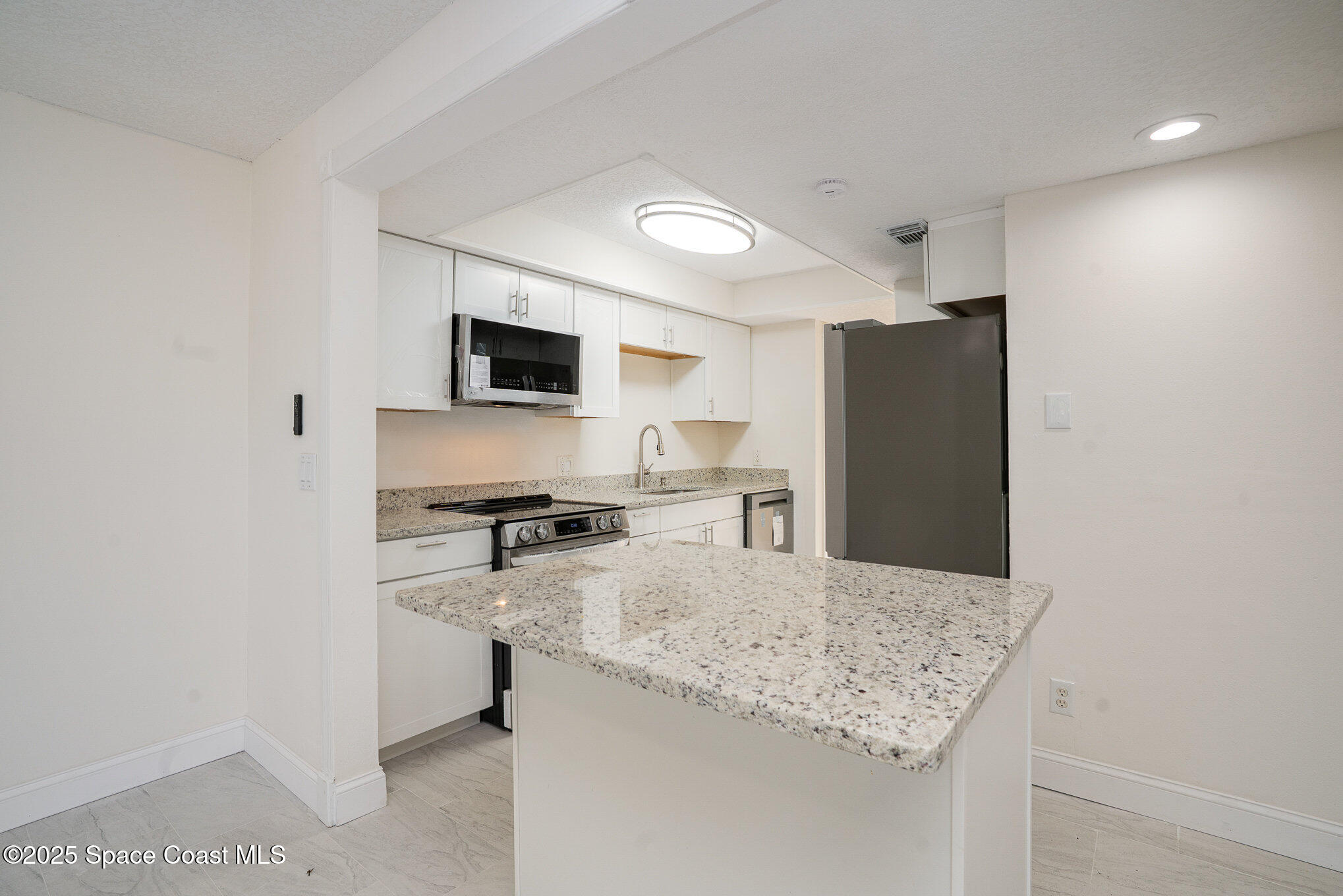 3444 Partridge Court Melbourne, FL 32935 - Photo 12 of 78 a kitchen with stainless steel appliances granite countertop a refrigerator stove microwave and sink