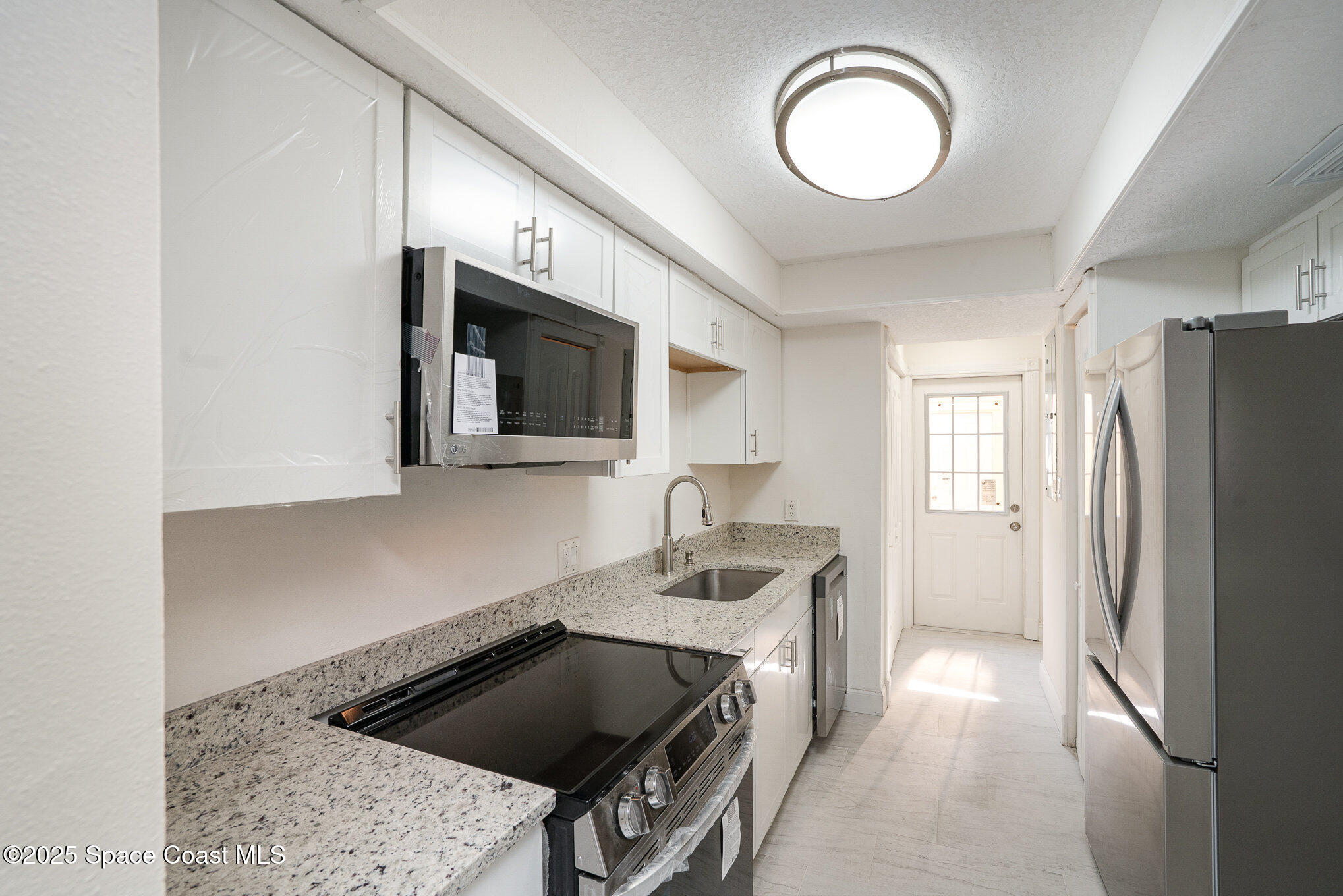 3444 Partridge Court Melbourne, FL 32935 - Photo 13 of 78 a kitchen with stainless steel appliances granite countertop a stove a sink and a microwave