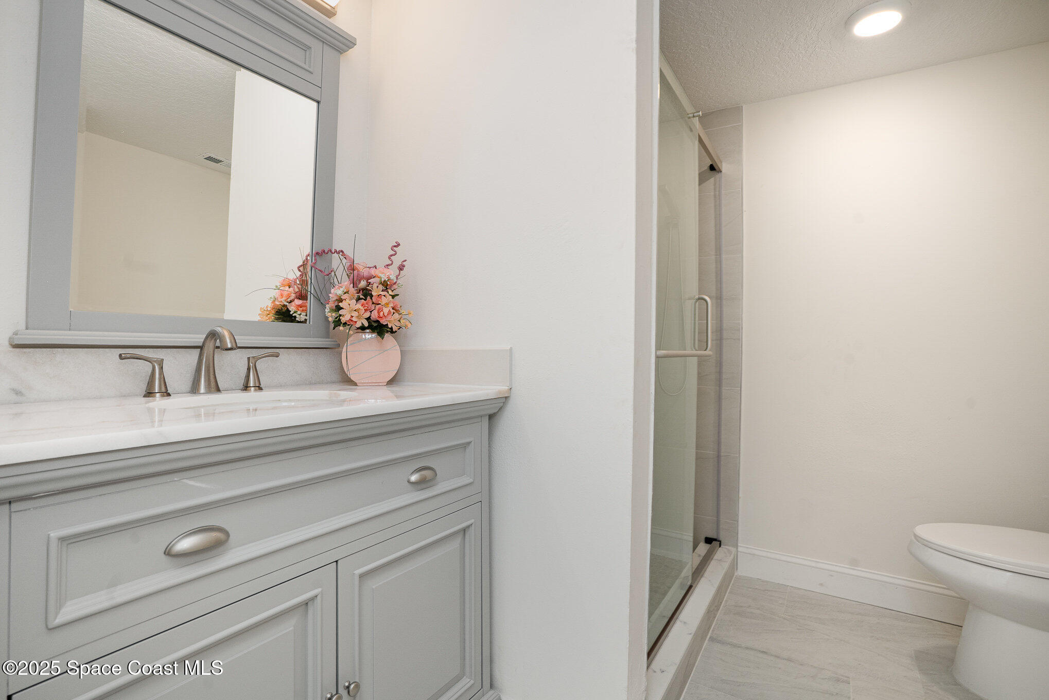 3444 Partridge Court Melbourne, FL 32935 - Photo 14 of 78 a bathroom with a sink a toilet and a mirror