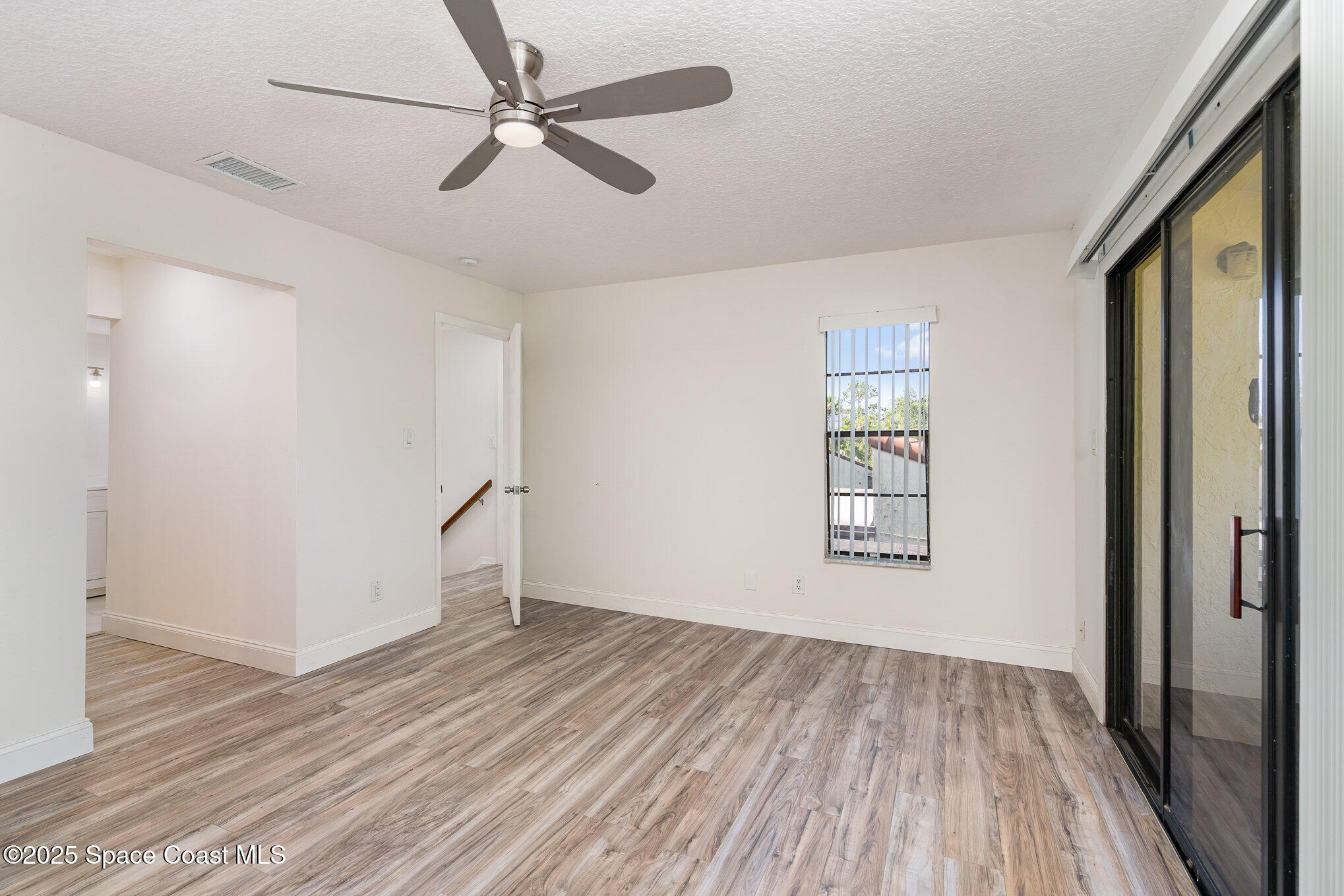 3444 Partridge Court Melbourne, FL 32935 - Photo 22 of 78 wooden floor in an empty room with a window