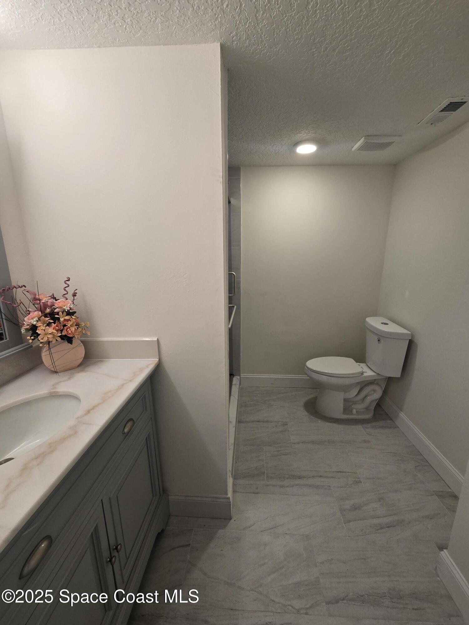 3444 Partridge Court Melbourne, FL 32935 - Photo 34 of 78 a bathroom with a sink a toilet and a mirror