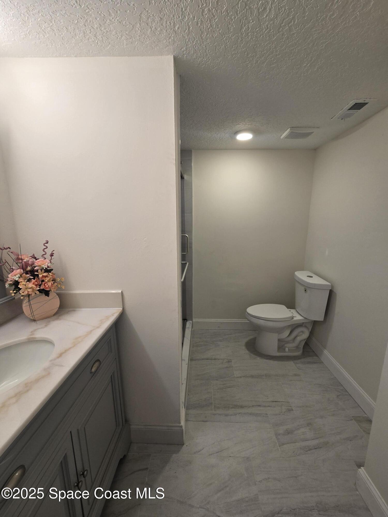 3444 Partridge Court Melbourne, FL 32935 - Photo 35 of 78 a bathroom with a sink a toilet and a mirror