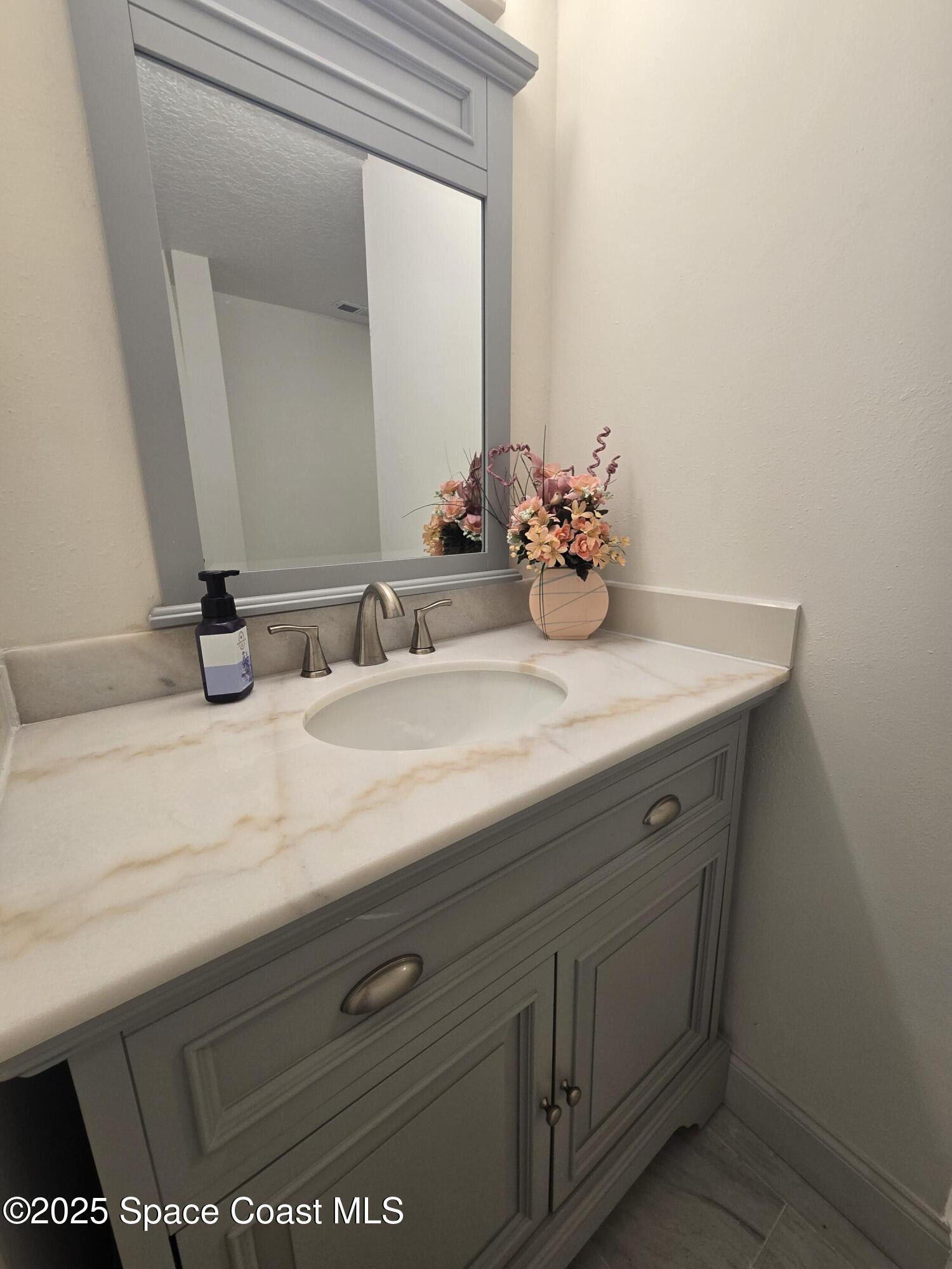 3444 Partridge Court Melbourne, FL 32935 - Photo 41 of 78 a bathroom with a sink and a mirror