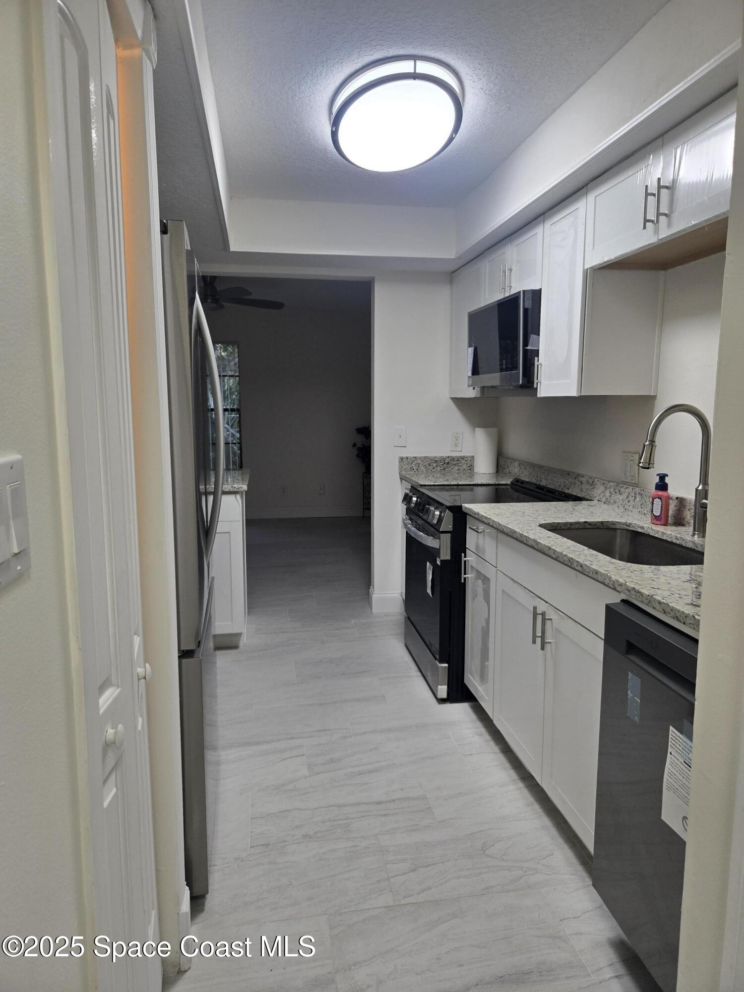 3444 Partridge Court Melbourne, FL 32935 - Photo 43 of 78 a kitchen with stainless steel appliances granite countertop a refrigerator and a stove