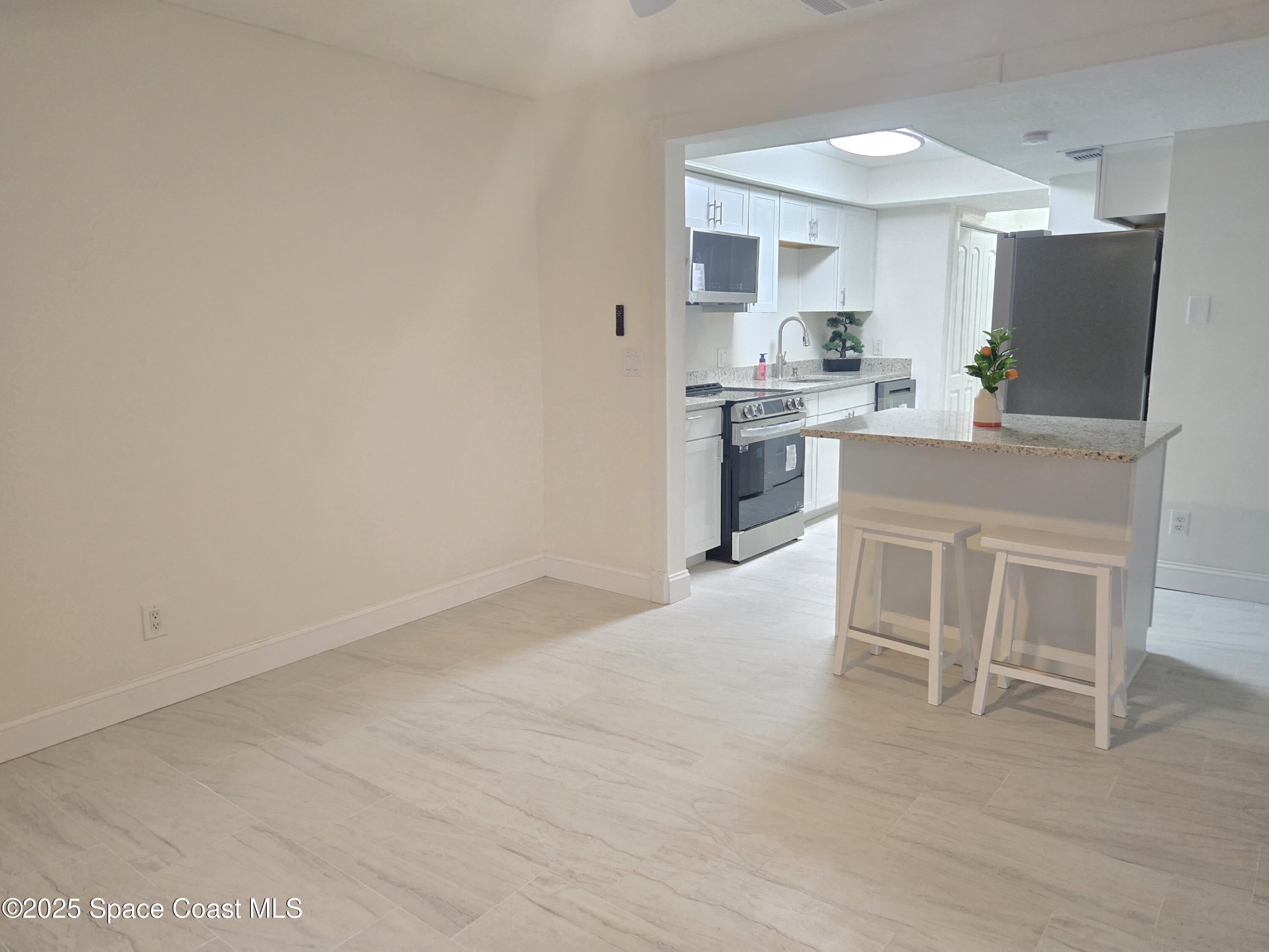 3444 Partridge Court Melbourne, FL 32935 - Photo 48 of 78 a kitchen with white cabinets and stainless steel appliances
