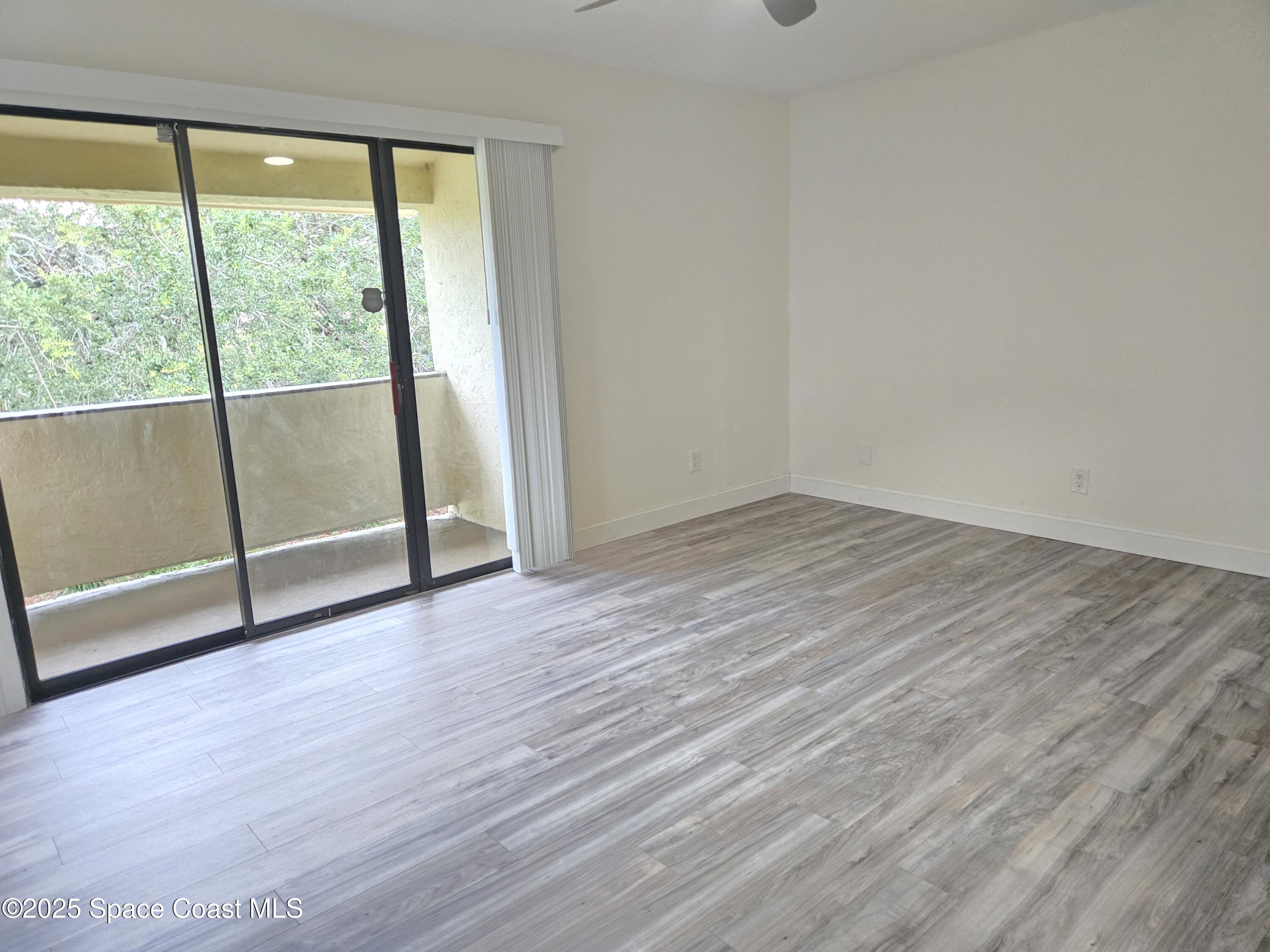 3444 Partridge Court Melbourne, FL 32935 - Photo 61 of 78 an empty room with wooden floor and door