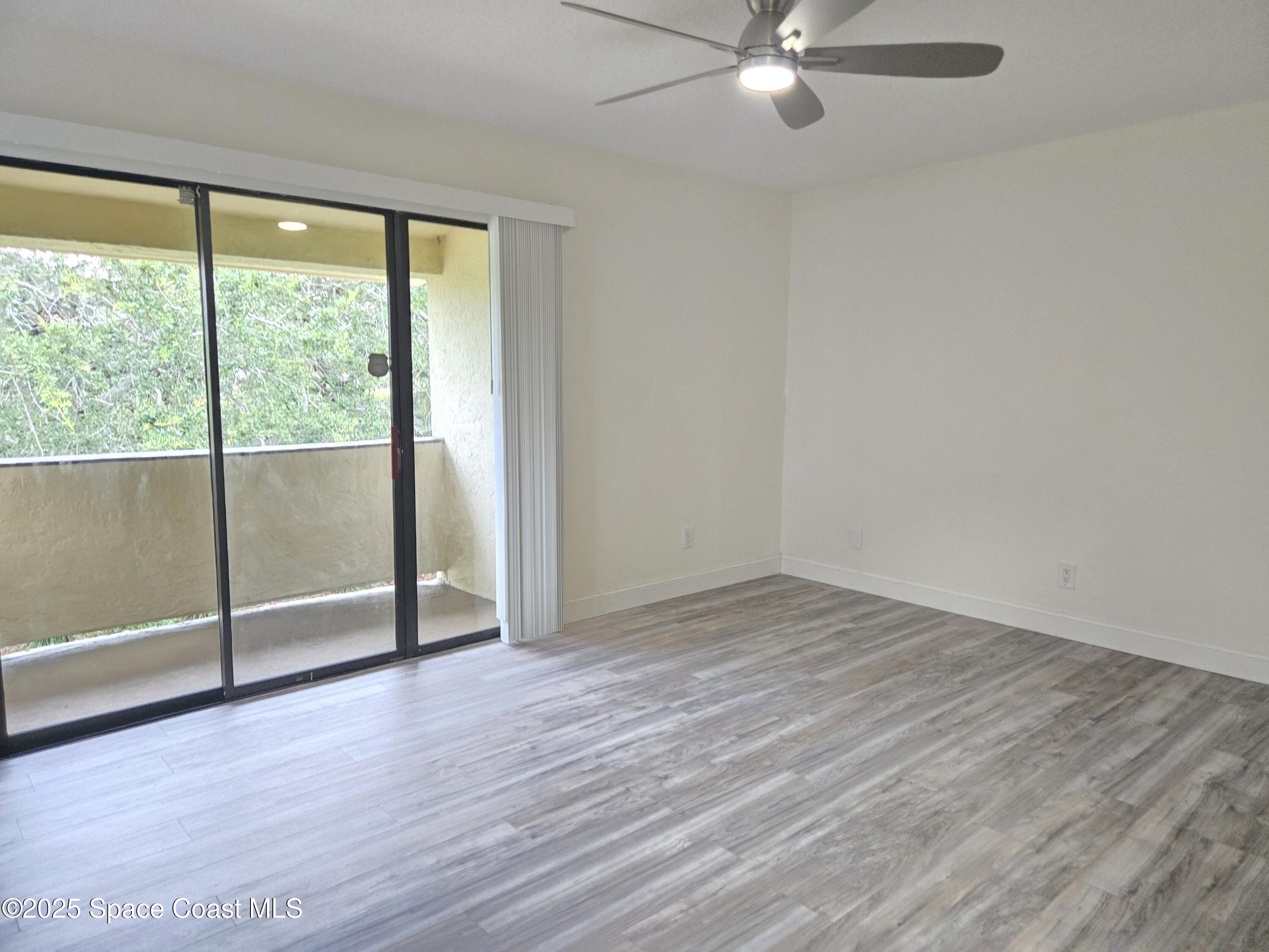 3444 Partridge Court Melbourne, FL 32935 - Photo 62 of 78 an empty room with wooden floor fan and windows