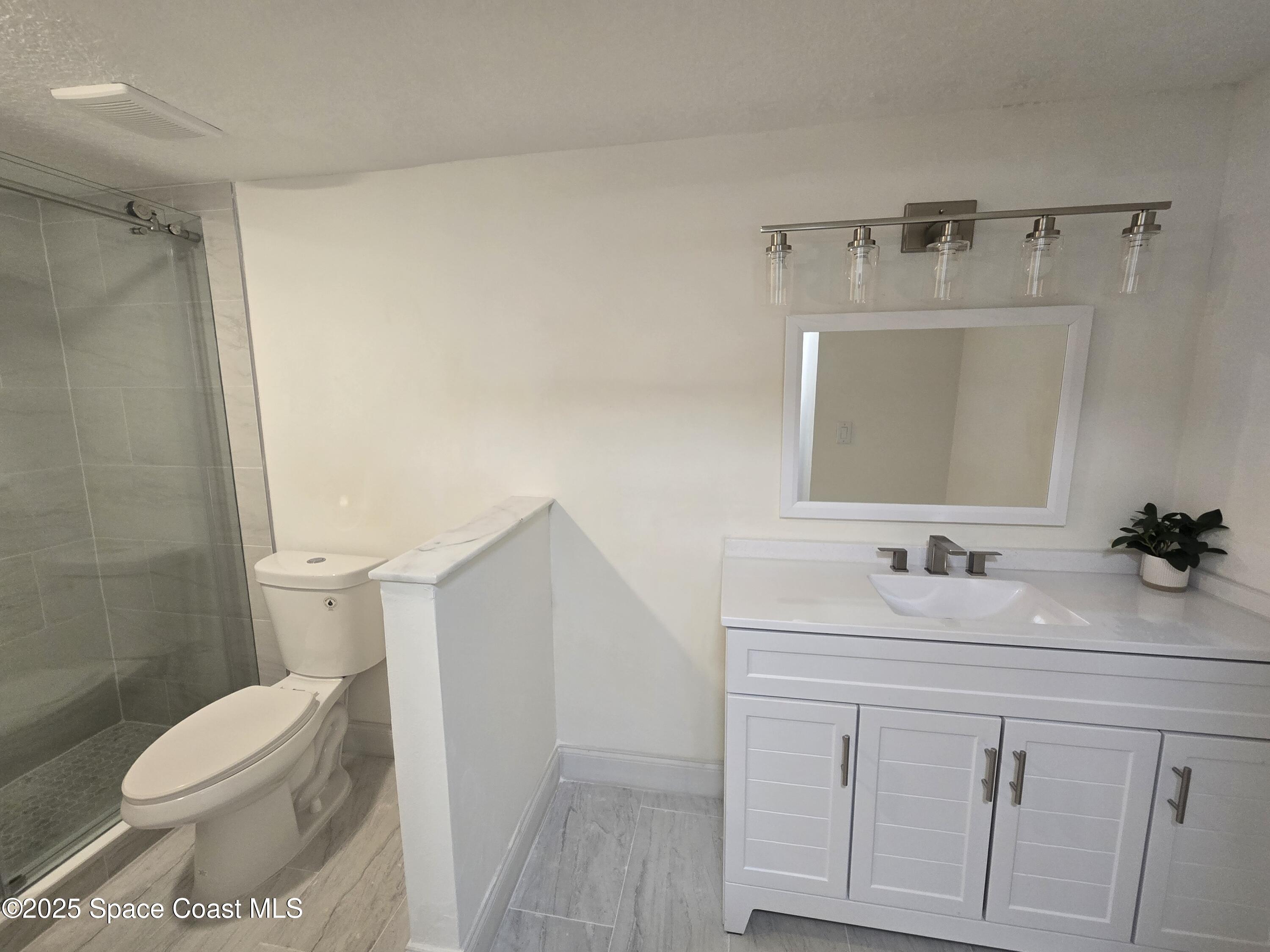 3444 Partridge Court Melbourne, FL 32935 - Photo 66 of 78 a bathroom with a sink a toilet and vanity