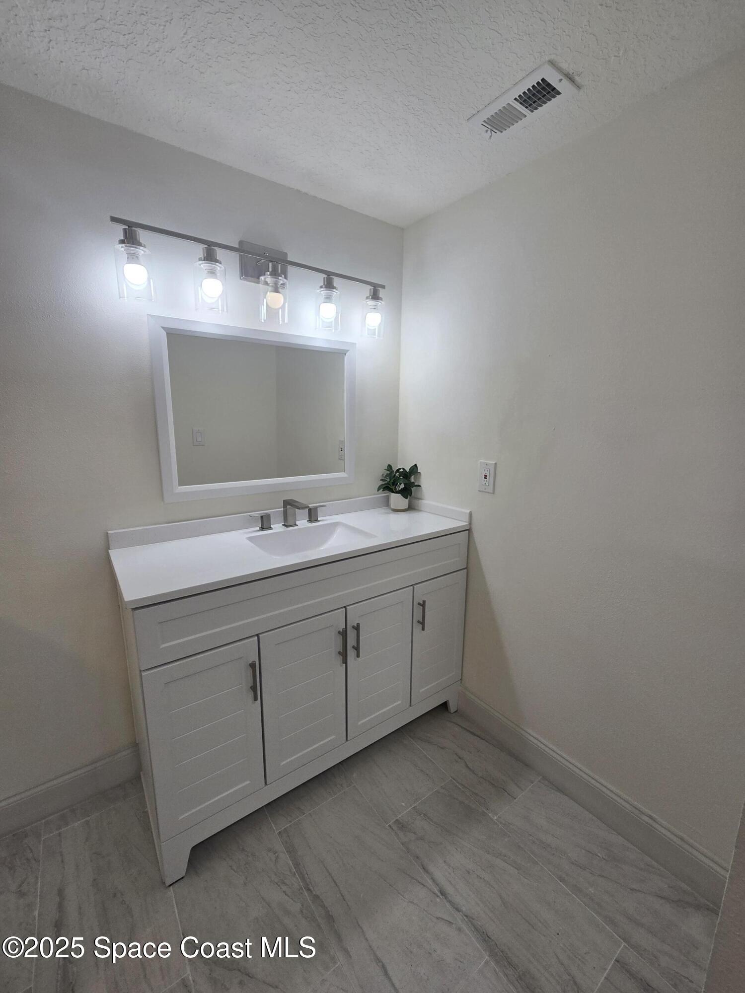3444 Partridge Court Melbourne, FL 32935 - Photo 67 of 78 a spacious bathroom with a double vanity sink and a mirror