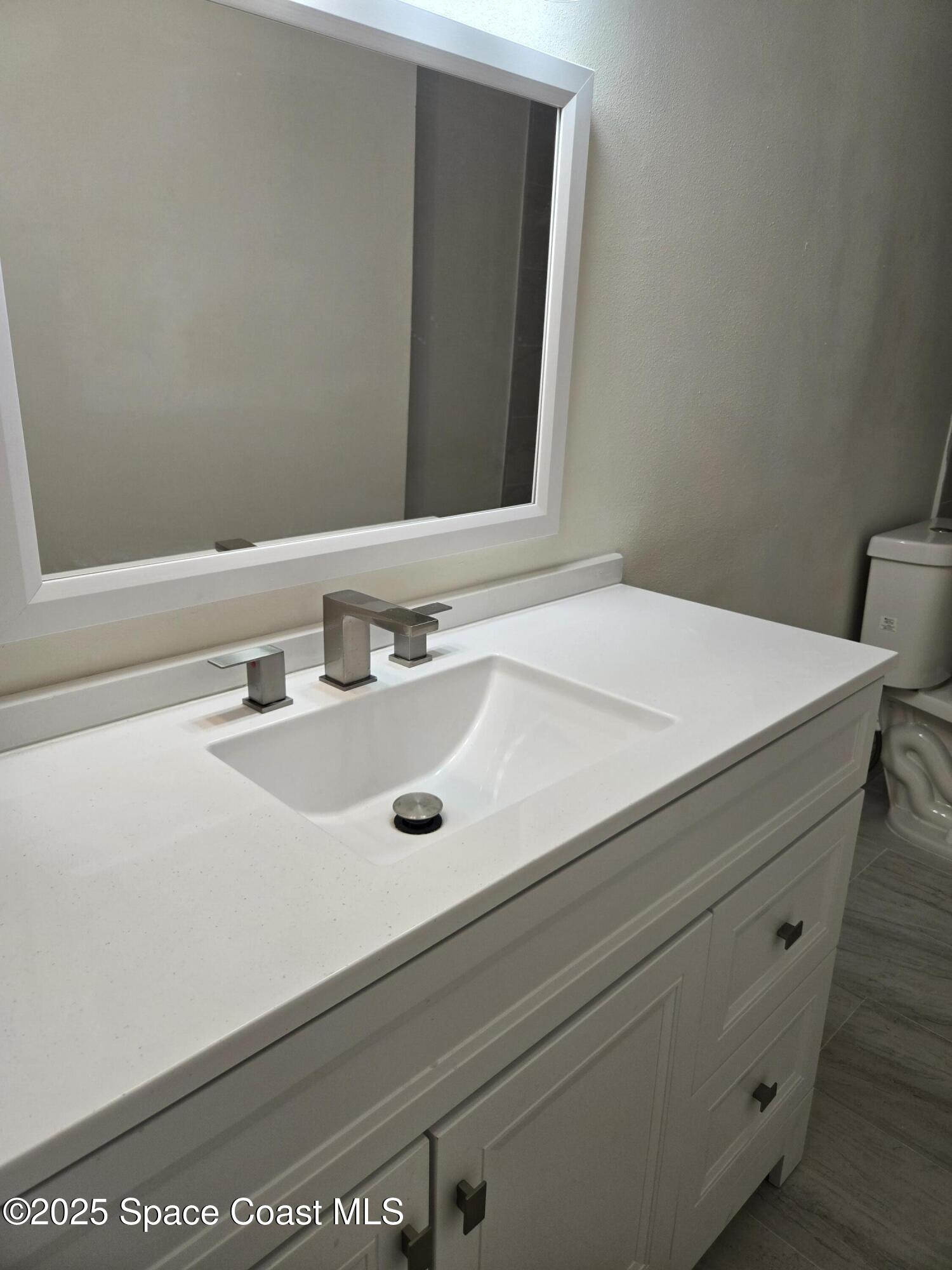 3444 Partridge Court Melbourne, FL 32935 - Photo 73 of 78 a bathroom with a sink and a mirror