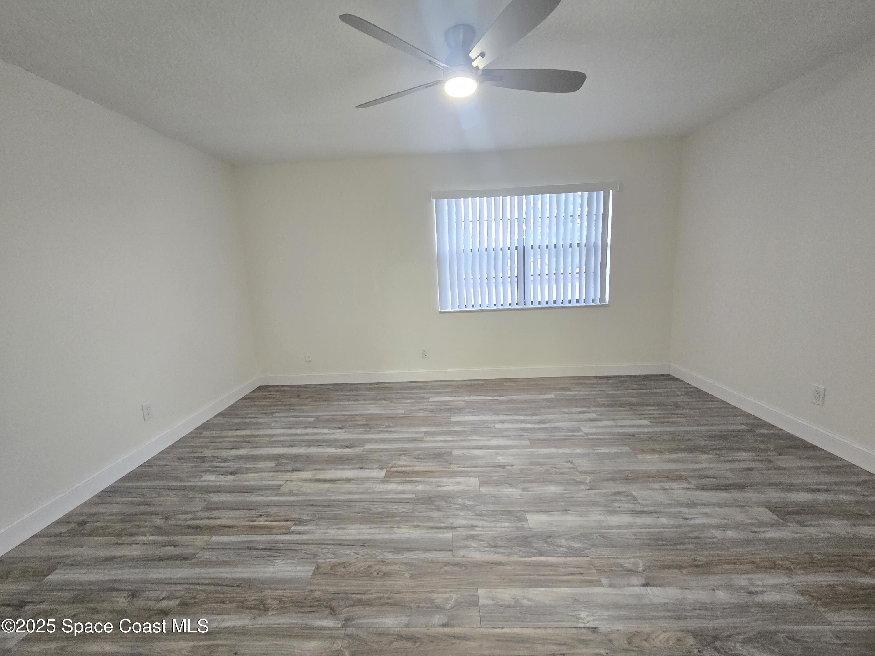 3444 Partridge Court Melbourne, FL 32935 - Photo 75 of 78 an empty room with wooden floor and windows