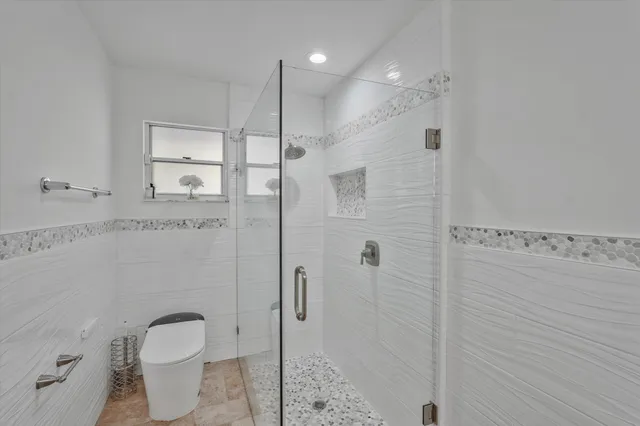 a bathroom with a granite countertop sink a toilet and shower