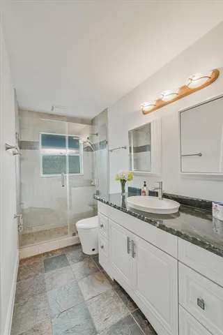 a spacious bathroom with a granite countertop sink mirror and double