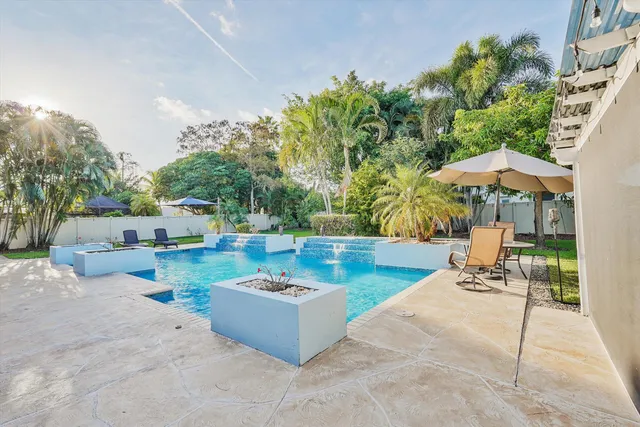 a view of a patio with a table and chairs under an umbrella