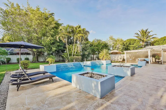 a view of a backyard with a patio and swimming pool