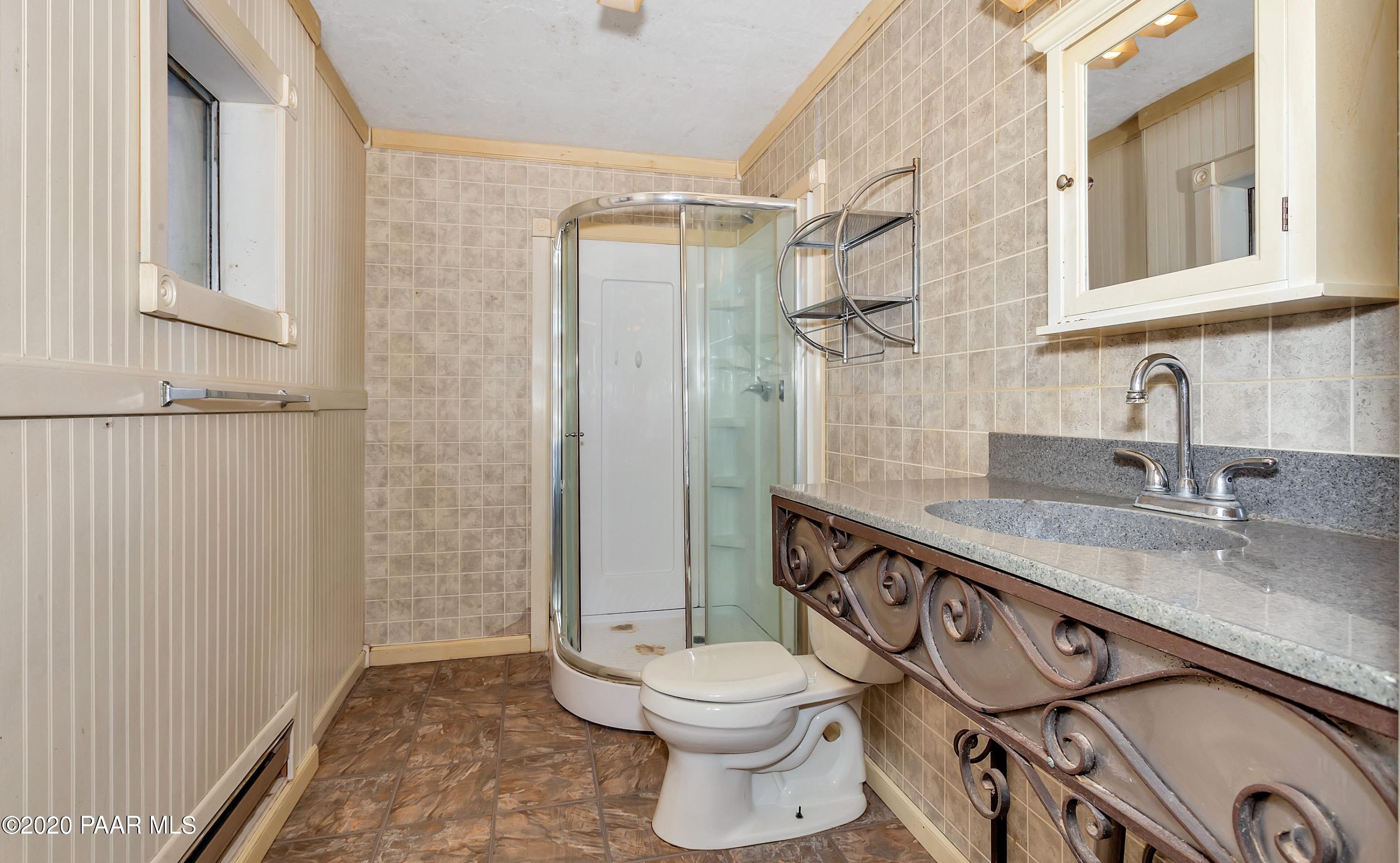 2571 North Reed Road Chino Valley, AZ 86323 - Photo 8 of 25 a bathroom with a granite countertop toilet sink and a shower