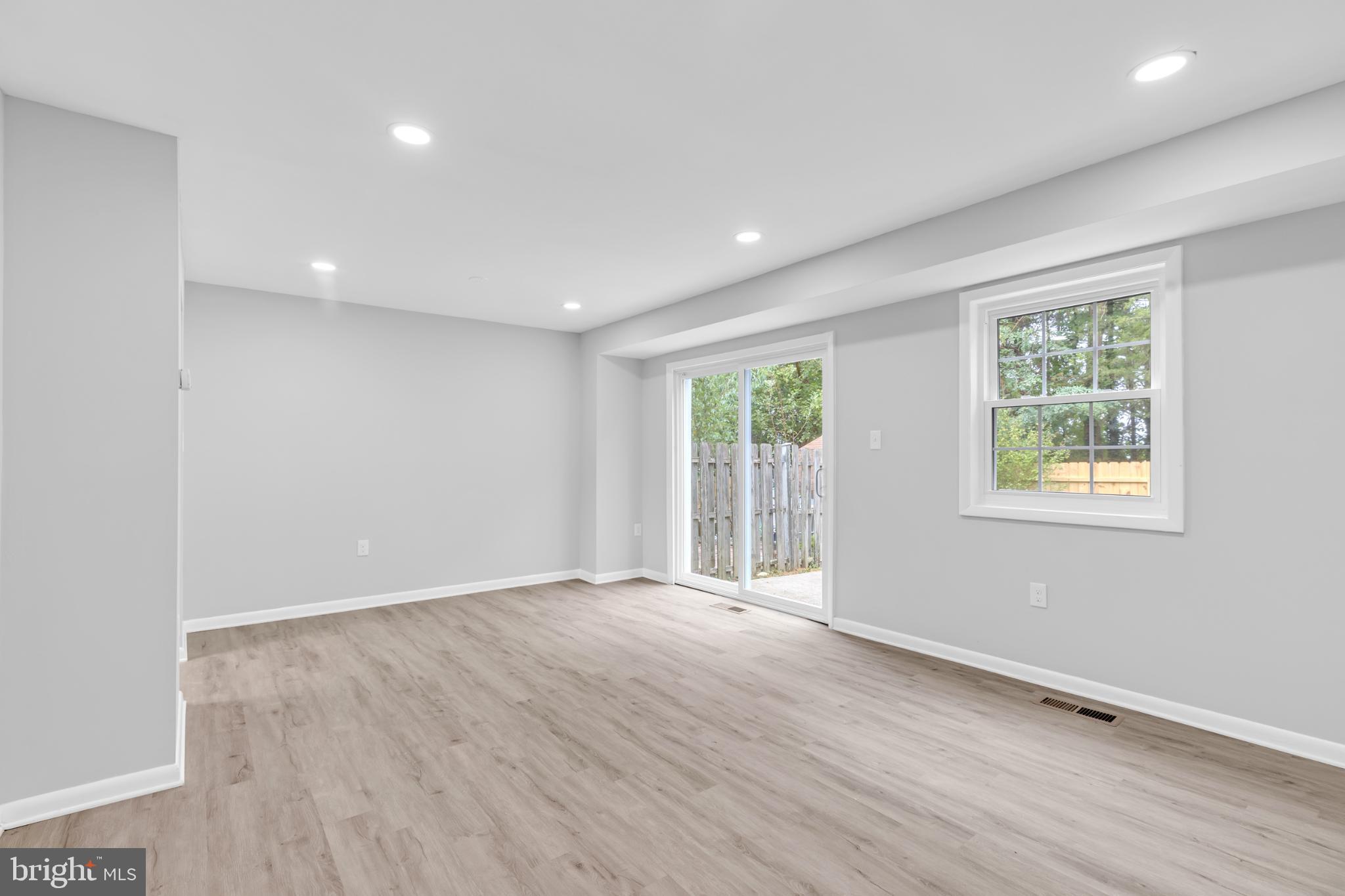 7403 Larne Lane Lorton, VA 22079 - Photo 9 of 31 an empty room with wooden floor and windows