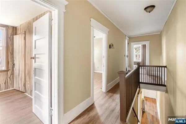 a view of a hallway with wooden floor and windows