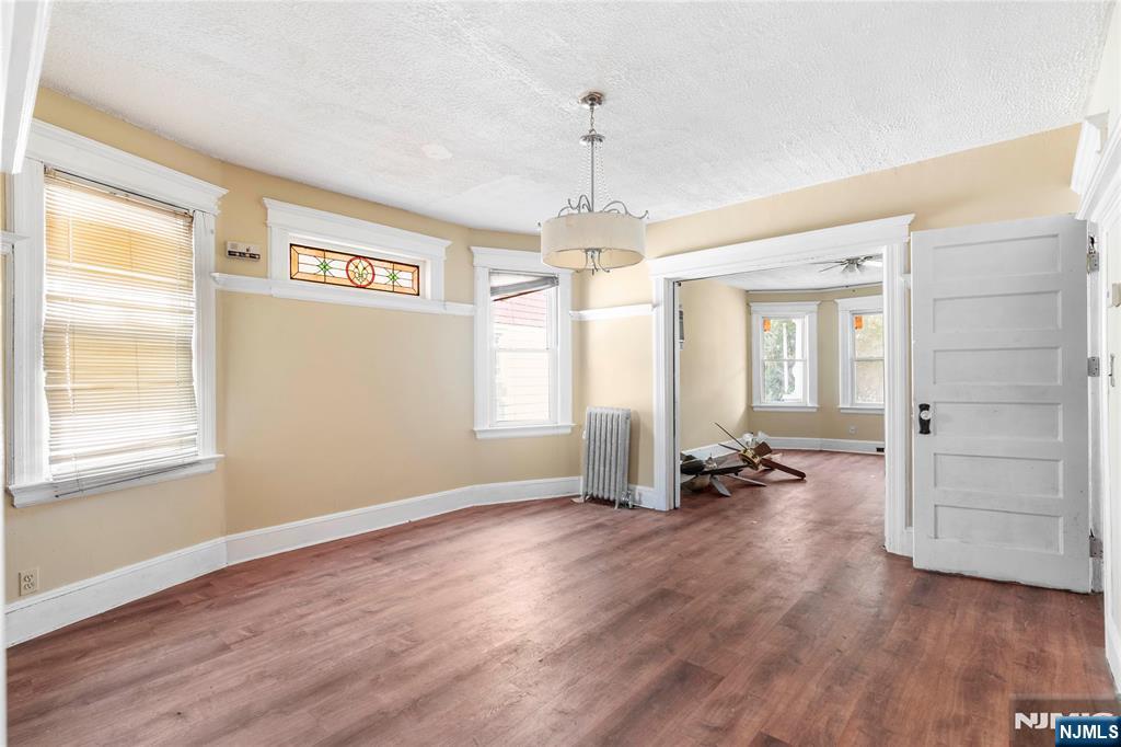 24 Swaine Place, Unit 22 West Orange, NJ 07052 - Photo 9 of 27 an empty room with wooden floor and windows