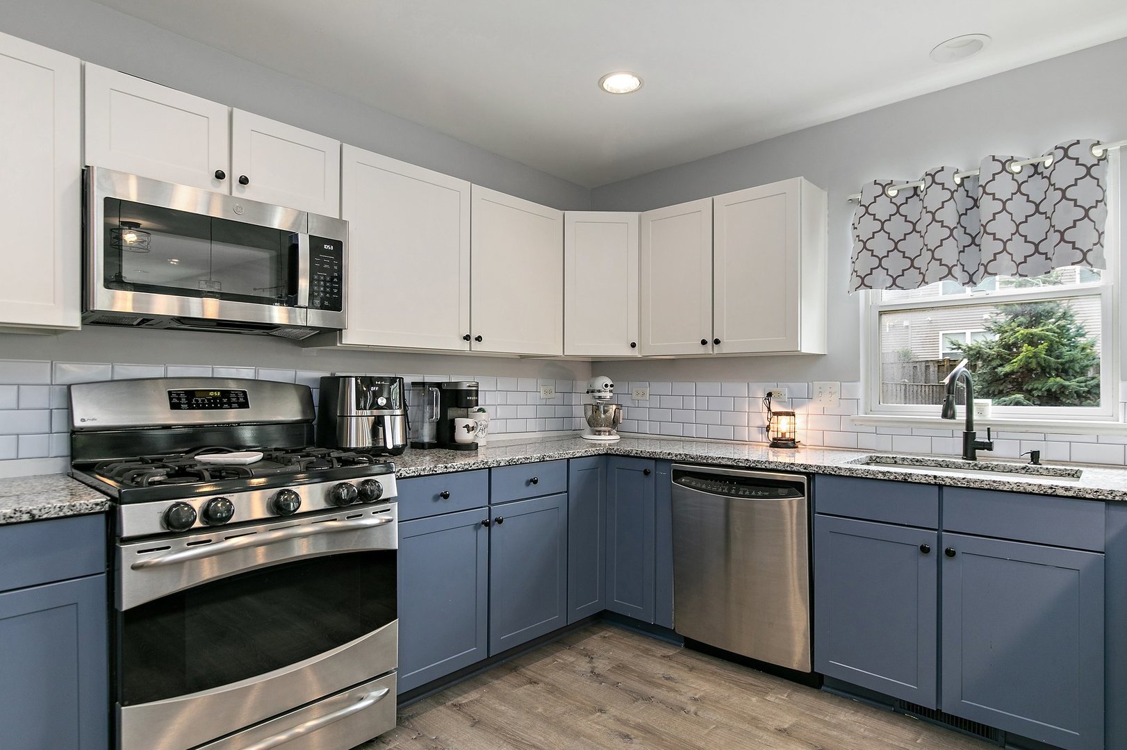 23 Boathouse Road Pingree Grove, IL 60140 - Photo 11 of 25 a kitchen with stainless steel appliances granite countertop grey cabinets a sink a stove a microwave and wooden cabinets