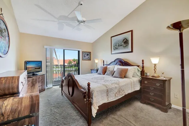a bedroom with a bed and a flat tv screen on dresser