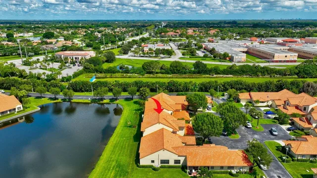 an aerial view of a house with a garden and lake view