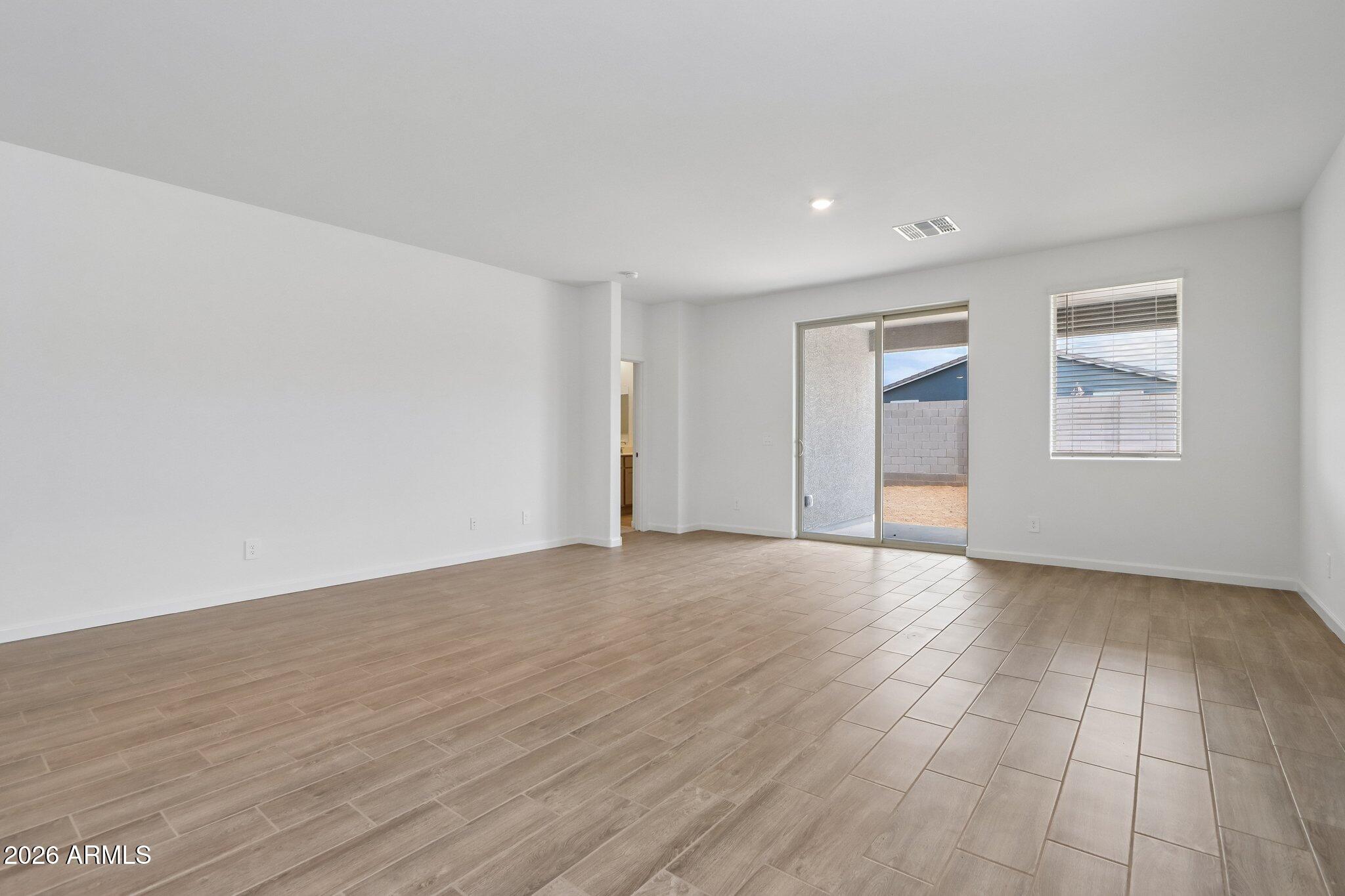 9544 West Gaby Road Tolleson, AZ 85353 - Photo 5 of 43 a view of an empty room with wooden floor and window