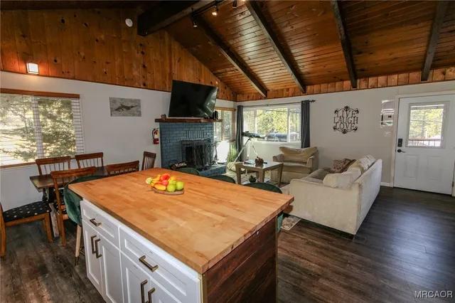 a living room with stainless steel appliances kitchen island furniture and a fireplace