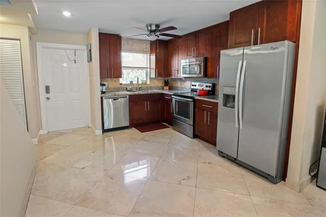 a kitchen with stainless steel appliances granite countertop a refrigerator sink and cabinets