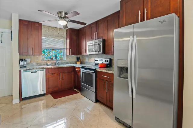 a kitchen with stainless steel appliances a refrigerator sink and cabinets