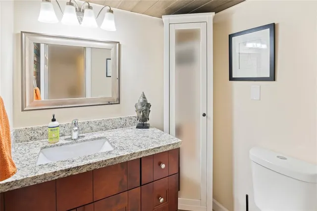 a bathroom with a granite countertop sink and a mirror