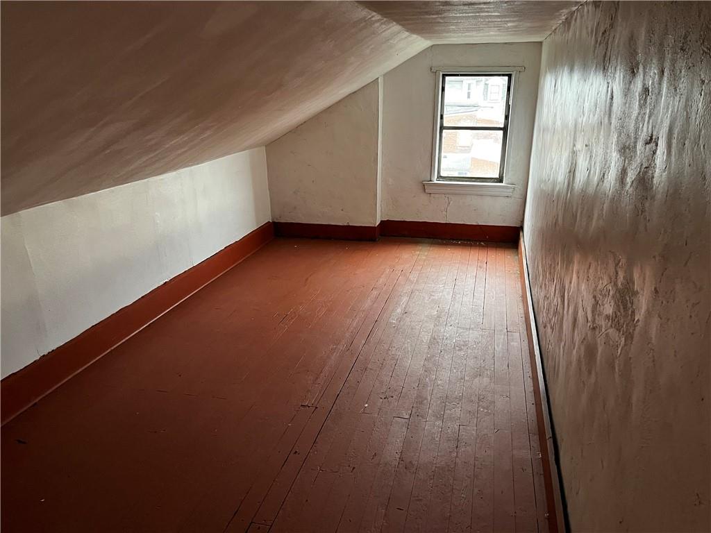 334 Main Street Pittsburgh, PA 15201 - Photo 20 of 24 an empty room with wooden floor and windows with curtains