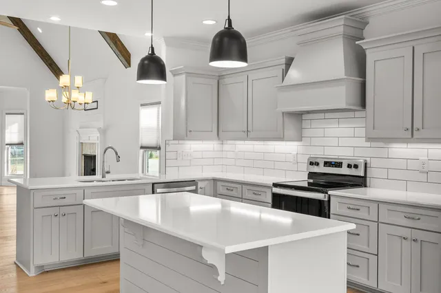 a kitchen with stainless steel appliances granite countertop a sink a stove and a wooden floors