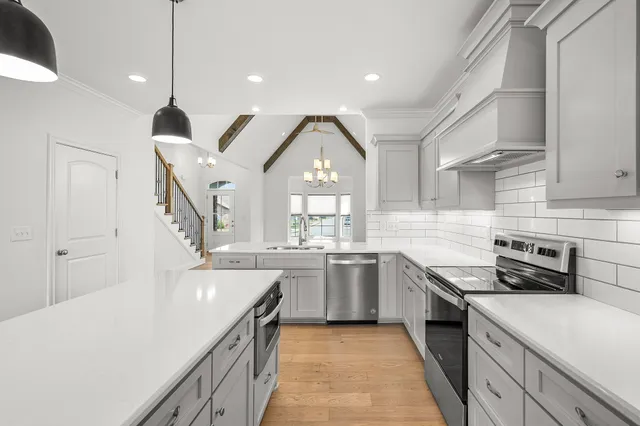 a kitchen with granite countertop a sink stove and cabinets