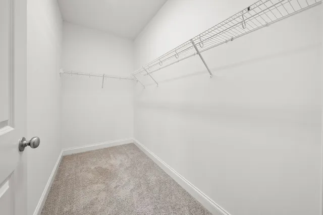 an empty room with chandelier fan and windows